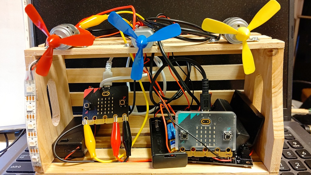 �����̃}�C�N���r�b�g(micro:bit)�ł͍��̃C���~�l�[�V�����E�����v�̓_�ŁA�E���̃}�C�N���r�b�g(micro:bit)�ł͏�̃��[�^�[�v���y���̓������R���g���[��